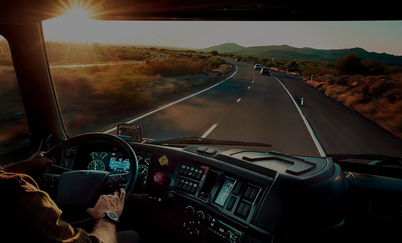 Vista desde la cabina de un camión circulando por carretera al amanecer