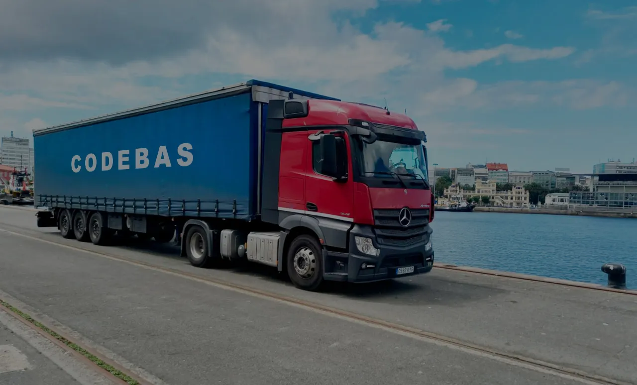 Camión con lona de Codebas estacionado junto al puerto